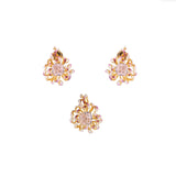 Pair of gold earrings with floral designs on a white background
